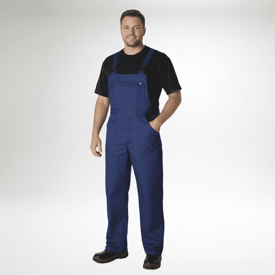 Pionier Arbeits-Latzhose Übergröße in Blau getragen von Mann mit schwarzem T-Shirt und Arbeitsschuhen