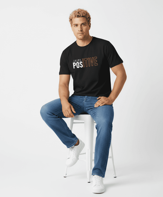 BigTiger schwarzes druck t shirt mit positivem Schriftzug getragen von Mann mit blonden Locken und blauen Jeans