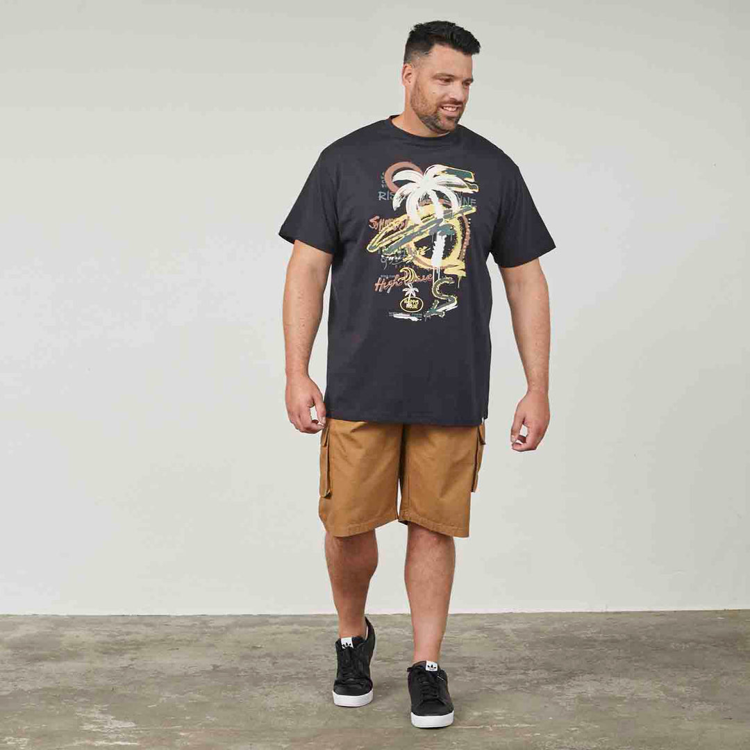 Schwarzes Allsize druck t shirt mit buntem Palmenmotiv getragen von Mann mit braunen Shorts und schwarzen Schuhen