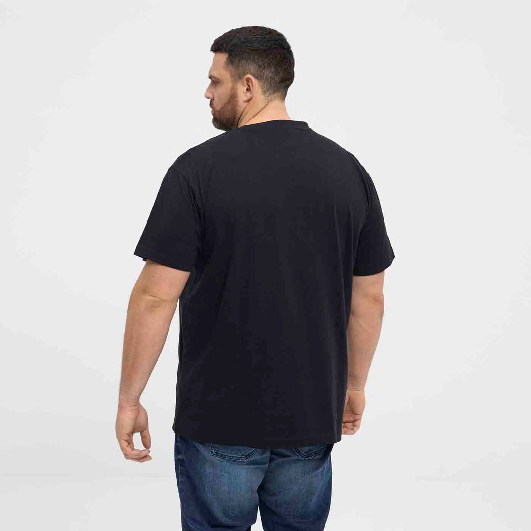 Mann trägt schwarzes bedrucktes t-shirt von Allsize von hinten mit blauer Jeans