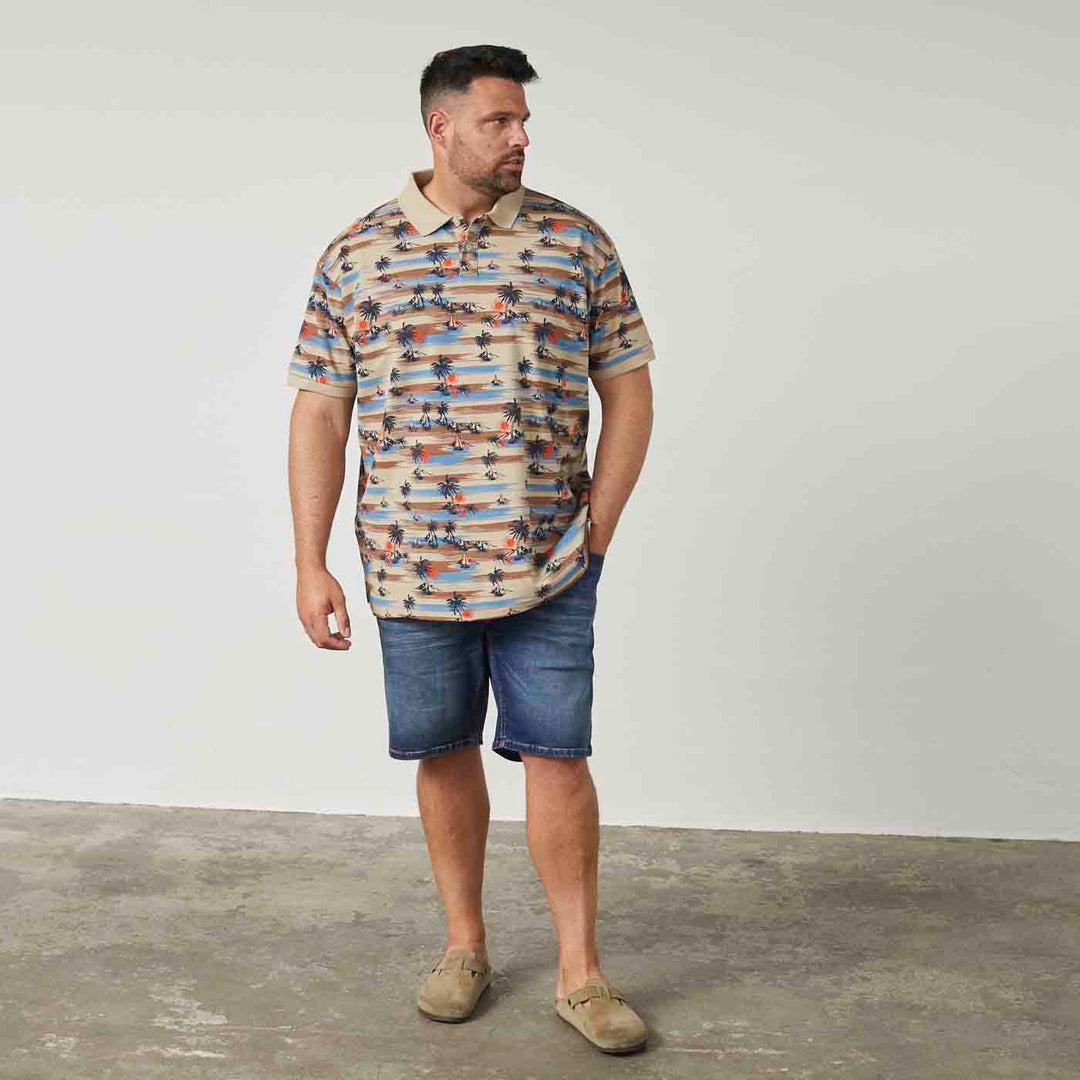 Herren trägt Allsize polo shirt mit buntem Muster und Jeansshorts in lässigem Stil