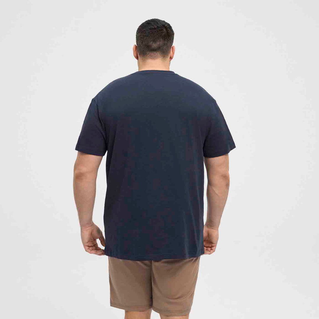 Mann trägt ein schlichtes dunkles bedrucktes t-shirt von Allsize, Rückansicht in Freizeitkleidung