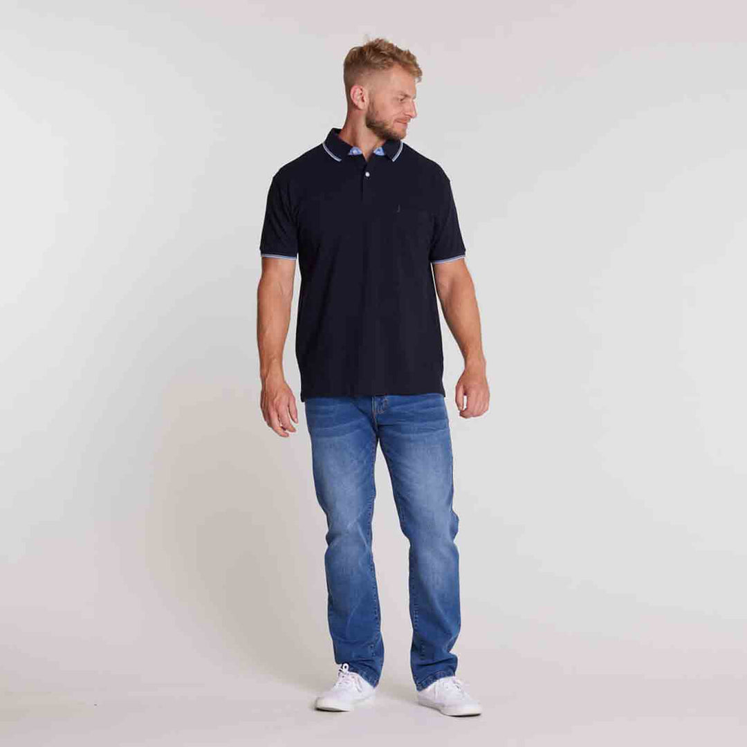 Herren polo shirt von Allsize in Schwarz mit weißem Kragen- und Ärmelrand kombiniert mit blauer Jeans und weißen Sneakern
