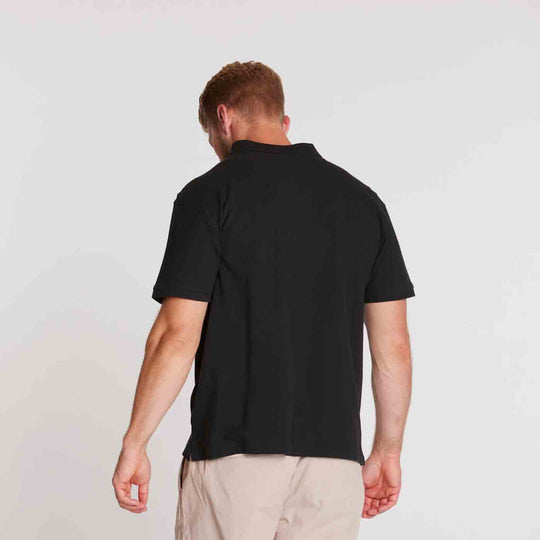 Schwarzes Allsize polo shirt mit kurzem Arm auf dem Rücken getragen von Mann vor hellgrauem Hintergrund