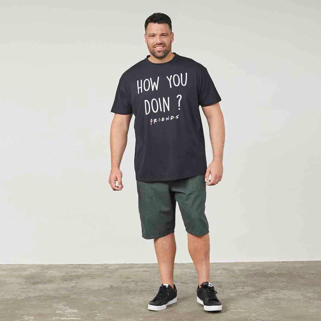 Schwarzes Allsize T Shirt best friends mit Aufdruck How You Doin getragen von Mann in grünen Shorts