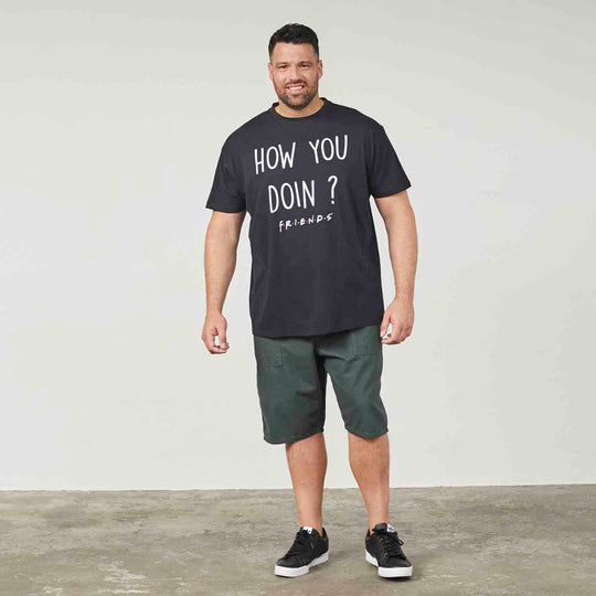 Schwarzes Allsize T Shirt best friends mit Aufdruck How You Doin getragen von Mann in grünen Shorts