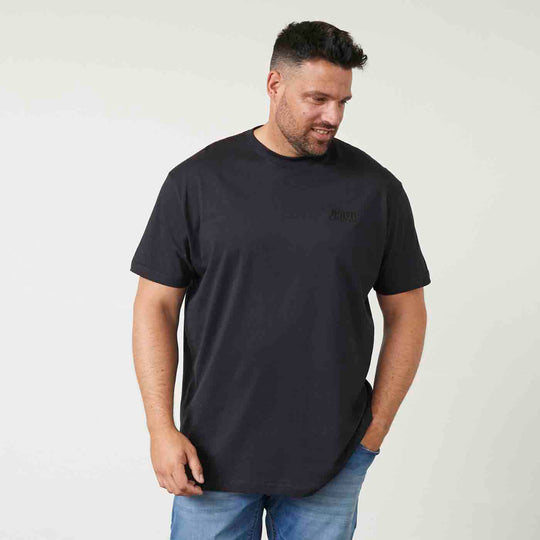 Schwarzes T shirt mit druck von Allsize getragen von Mann mit blauen Jeans vor weißem Hintergrund